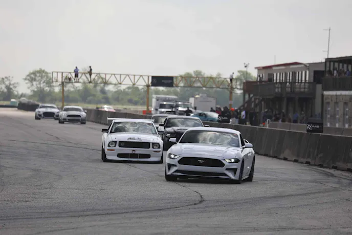 White Mustangs on track going into a corner
