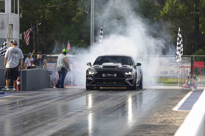Black mustang burnout on drag strip