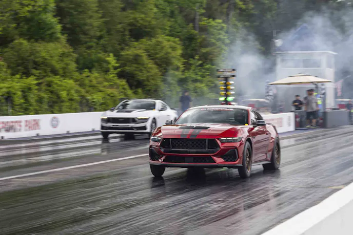 Two mustangs racing down the drag strip