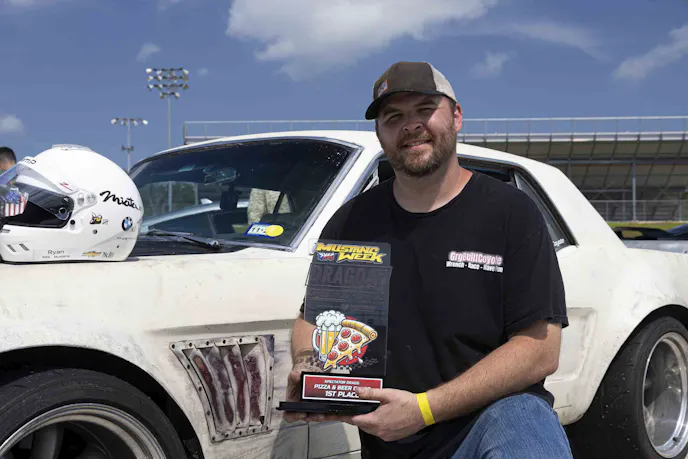 Man holding trophy in front of his mustang