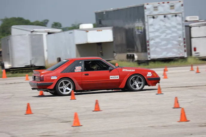 Red Foxbody Mustang running autocross course