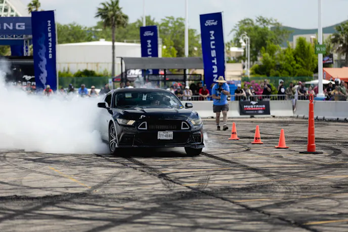 Black S550 Mustang with smoke from rear tires